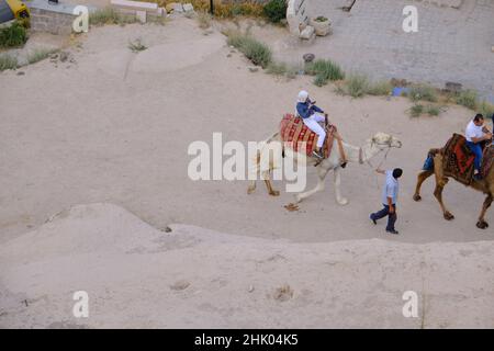 22.07.2021. Cappadocia, Turquía. Atracción turística, paseos en camello y mujeres árabes en camello en urgup. Foto de stock