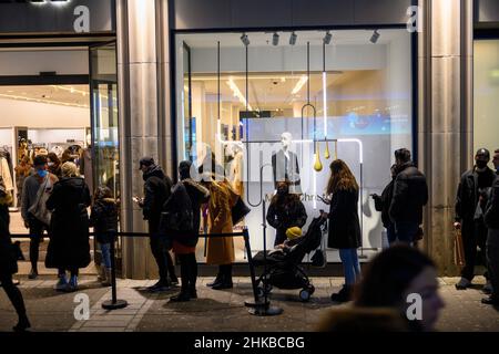 Los pasaportes de vacunación se comprueban en la entrada de una boutique de moda en el centro de la ciudad de Düsseldorf, NRW, Alemania, en 11.12.2021 Foto de stock