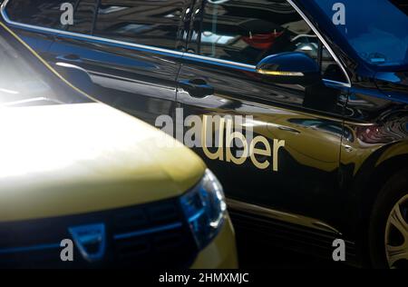 Bucarest, Rumania - 20 de enero de 2020: Un coche con el logotipo de Uber se ve en el tráfico cerca de un taxi amarillo en una calle en Bucarest. Foto de stock