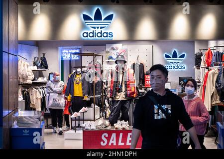 Los compradores ven en la tienda Adidas de la marca alemana de ropa deportiva multinacional en Hong Kong de stock - Alamy