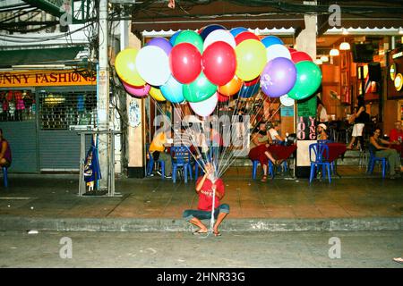 El hombre espera a los turistas en Khaosan Road para vender globos Foto de stock