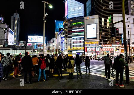 Shibuya, Japón - 1 de abril de 2019: Famoso barrio Shibuya cruzándose en el centro de la ciudad con luces de neón publicidad cartelera para Bic Camera y cro Foto de stock