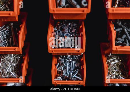 Cajas pequeñas con tornillos y tuercas en un taller Foto de stock