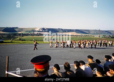 Los escolares participaron en ejercicios de entrenamiento militar como cadetes del ejército, sur de Inglaterra, Reino Unido, finales de 1950s marchando a una banda de músicos