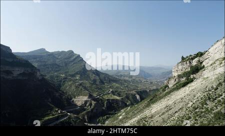 Impresionante paisaje alpino con laderas verdes de montañas vírgenes sobre fondo de cielo azul. Acción. Naturaleza veraniega en la república de Daguestán, Rusia Foto de stock