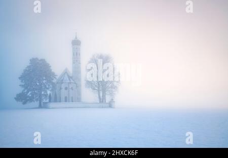 Iglesia de San Colomán cerca de Schwangau en la niebla en un frío día de invierno. Baviera, Alemania, Europa