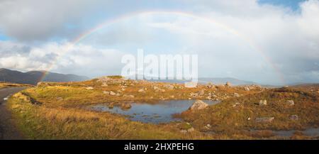 Un colorido arco iris sobre el paisaje rural y los humedales de la isla de Lewis y Harris en las Hébridas Exteriores de Escocia.