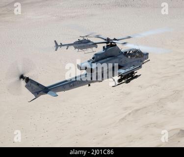 Un Viper AH-1Z (frontal) con el Escuadrón de Evaluación de Pruebas y Operaciones Marinas 1 (VMX-1), y un helicóptero MQ-8C Fire Scout no tripulado asignado al Escuadrón de Combate de Mar de Helicóptero 23 (HSC-23), conducen la Coordinación de Huelga y Entrenamiento de Reconocimiento cerca de El Centro, California, el 10 de marzo de 2022. El propósito de este ejercicio fue proporcionar familiarización y desarrollo conceptual de la formación de equipos tripulados y no tripulados. (EE.UU Marine Corps foto por Lance Cpl. Jade Venegas)