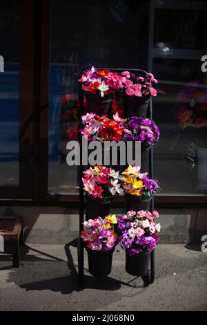 Flores artificiales se venden en la tienda. En cestas son diversos ramos de flores  artificiales para la venta. Flores artificiales para decorar el interior  Fotografía de stock - Alamy
