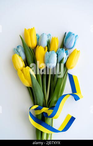 Ramo de tulipanes con cinta azul y amarilla sobre fondo negro Fotografía de  stock - Alamy