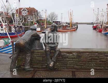 Neuharlingersiel, Alemania - Dic 31 2015 Escultura de bronce de un viejo y joven pescador en el puerto de Neuharlingersiel Foto de stock