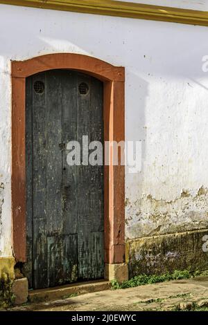 Antigua puerta de madera en una casa de arquitectura colonial Foto de stock