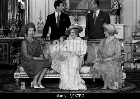 La princesa Diana, sostiene a su hijo el príncipe Guillermo en sus brazos en la sala de dibujo blanca del palacio de Buckingham después de una ceremonia privada de bautizo en la sala de música. Ella está rodeada por miembros de la familia: Fila de atrás de izquierda a derecha: Pricne Charles, el príncipe Felipe, el duque de Edimburgo. Sentado de izquierda a derecha: La Reina Isabel II y la Reina Isabel, la Reina Madre. El Príncipe fue bautizado con el traje tradicional de encaje de Honiton. 4th de agosto de 1982. Foto de stock