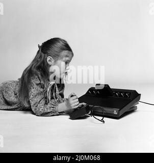 Una joven jugando en el Atari 2600, una consola de videojuegos de Atari. 1980 de diciembre. Foto de stock