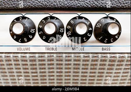 Vista de primer plano de los mandos de un amplificador para ajustar el sonido de los instrumentos musicales de cuerda Foto de stock