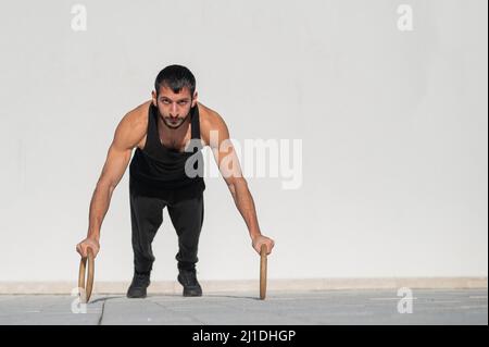 Hombre en ropa deportiva se prepara para hacer ejercicio al aire