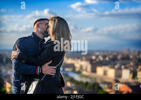 Románticos besos y vistas de Florencia desde la Piazzale Michelangelo con el río Arno, el dique de la ciudad y la famosa catedral florentina Foto de stock