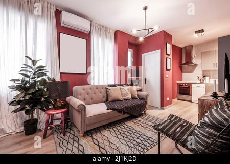 Apartamento con sala de estar con sofá de tres plazas en tela marrón, cómoda en madera encurtida, plantas decorativas interiores y aire acondicionado Foto de stock