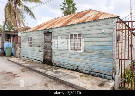 Pequeña casa con fachada erosionada y techo oxidado en los suburbios de Willemstad, Curacao
