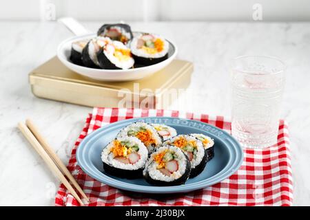Kimbap de rollo coreano (kimbbo o kimbap) hecho de arroz blanco al vapor (bap) y otros ingredientes, como Kyuri, zanahoria, salchichas, bastón de cangrejo, o bien Foto de stock