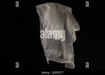 guante blanco desechable con palma que muestra aislado sobre fondo negro Foto de stock
