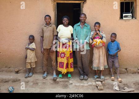 Triphonie Bosenibo, de 36 años, esposo Daniel Bwanakweri, de 45 años, y tiene 7 hijos. Los 5 presentes Jean Didier Dufatanye, 18, Sandrine Umuruta Satte, 12, Jean D'Amour Niyonkwizera, 9, Emmanuel Niyonshuti, de 7 años, y Valentine Umutesi, de 18 meses. La familia solía comer una vez al día y a menudo pasa hambre, trabajando a trabajadores asalariados en la tierra de otras personas. Ahora comen dos o tres veces al día incluyendo vegitables. Daniel dice que él nunca piensa en trabajar para otras personas ahora. Fotografía de Mike Goldwater Foto de stock