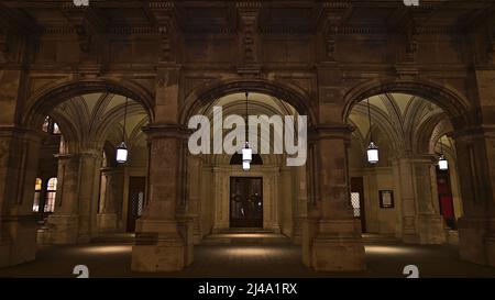 Vista frontal de la entrada lateral del popular edificio de la Ópera Estatal de Viena en el centro antiguo de Viena, Austria en la oscuridad con lámparas y fachada. Foto de stock