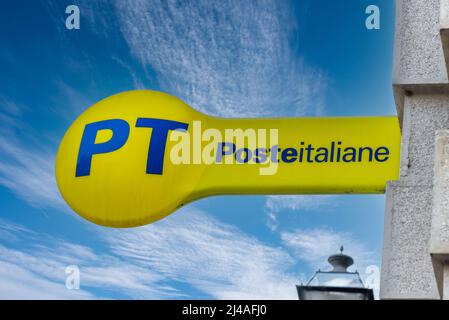 Cuneo, Italia - 11 de abril de 2022: PT Poste Italiane, Italia El logotipo del poste en el signo amarillo en cielo azul, fuera de la oficina de correos italiana. Tex: Posteitaliano (ITA Foto de stock