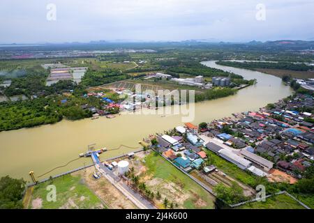 Vista aérea arriba abajo de la aldea de pescadores con barcos de pesca y techo de la casa en el muelle en suratthani Tailandia Foto de stock