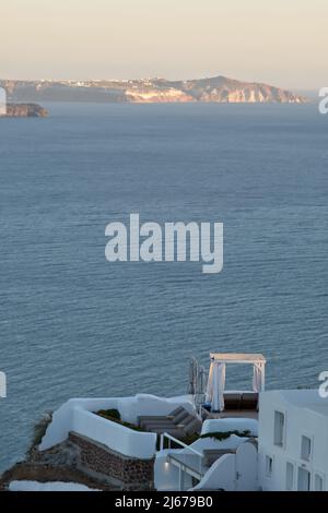 Oia, Grecia - 11 de mayo de 2021 : un hotel de lujo con tumbonas con vistas al mar Egeo en Oia Santorini Foto de stock