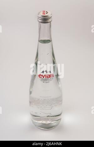 Agua mineral natural Evian con logotipo. Elegante botella de vidrio de 750 ml de marca francesa sobre fondo blanco.