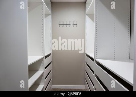 Vista de armarios altos y blancos y cajones dentro de un estrecho vestidor  dentro de un dormitorio principal Fotografía de stock - Alamy