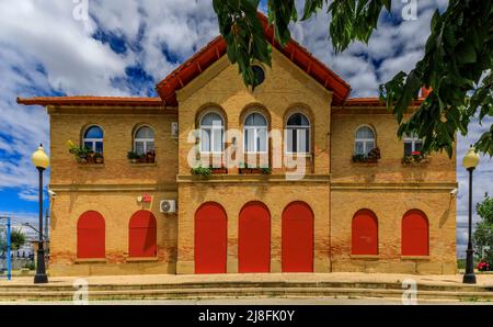 Fachada de ladrillo con persianas rojas y puertas de la estación de tren de Olite o Erriberri en Navarra, norte de España Foto de stock