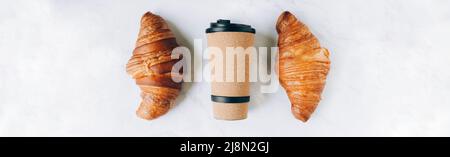 Cruasanes con café para llevar en una taza ecológica, pancarta de desayuno para llevar. Diseño plano, vista njp, espacio de copia Foto de stock