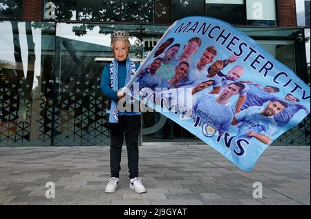Un fan de Manchester City ondea una bandera con una máscara de la Reina Isabel II durante el desfile de trofeos de la Premier League en Manchester. Fecha de la foto: Lunes 23 de mayo de 2022. Foto de stock