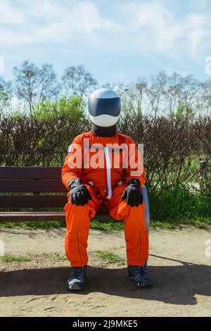 Hombre astronauta sentado en banco en la plataforma ferroviaria Fotografía  de stock - Alamy