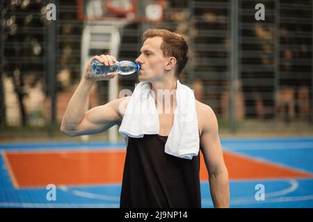 el hombre sostiene la toalla en el gimnasio tomando un descanso del  entrenamiento Fotografía de stock - Alamy