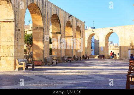 Valletta, Malta - 29 DE ABRIL de 2019: La gente disfruta de una agradable noche y puesta de sol. Galería de arcos de los Jardines superiores de Barrakka. Soleado calma impresionante puesta de sol. Foto de stock