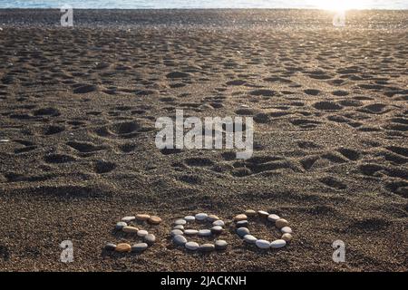Letras SEO abreviatura Search Engine Optimization hecho de piedras en la playa de arena. Foto de stock