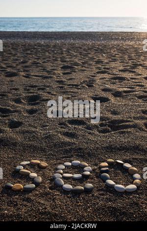 Letras SEO abreviatura Search Engine Optimization hecho de piedras en la playa de arena. Foto de stock