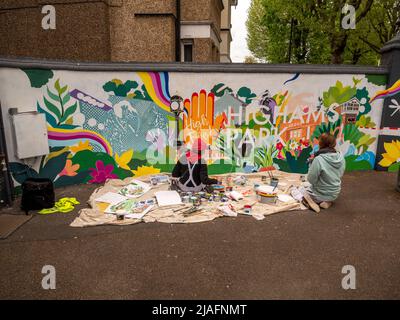 Highams Park London, encargó a los pintores el arte de pintar con hojas de polvo sobre una pared blanca que representa Highams Park en Londres Foto de stock