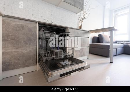 Abierto lavavajillas vacío en la cocina contemporánea gris azul con encimera  compacta de alta presión laminado HPL y fregadero cuadrado negro y azulejos  Fotografía de stock - Alamy