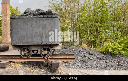 camión de carbón clásico en raíles llenos de carbón negro Foto de stock