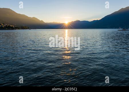 Sunbeam sobre el lago alpino Maggiore con la montaña en Locarno, Suiza. Foto de stock