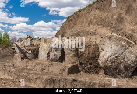 Paisaje con excavaciones Lugar de placas de lápida de granito en el antiguo montículo funerario en Novooleksandrivka pueblo en el centro de Ucrania de alrededor de 1200
