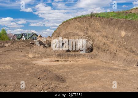 Paisaje primaveral con excavaciones Lugar de placas de lápida de granito en el antiguo montículo funerario en Novooleksandrivka pueblo en Ucrania de alrededor de 1200s