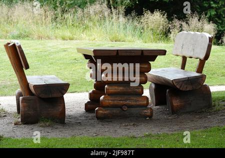 Una robusta mesa de picnic de madera y bancos en el parque Foto de stock