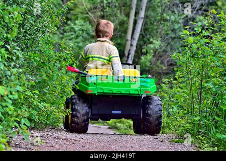 Niño de 2 años conduciendo su moto de juguete con gran velocidad a través  de su patio de recreo Fotografía de stock - Alamy