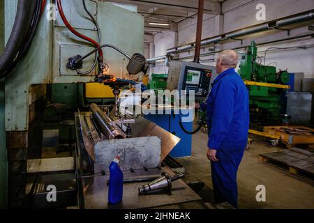 Ingeniero de fábrica que trabaja en la taladradora CNC Foto de stock