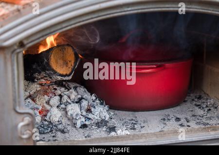 Cocinar al aire libre en una olla de hierro fundido sobre una fogata de  madera abierto en un campamento durante una recreación de la revolución  americana Fotografía de stock - Alamy